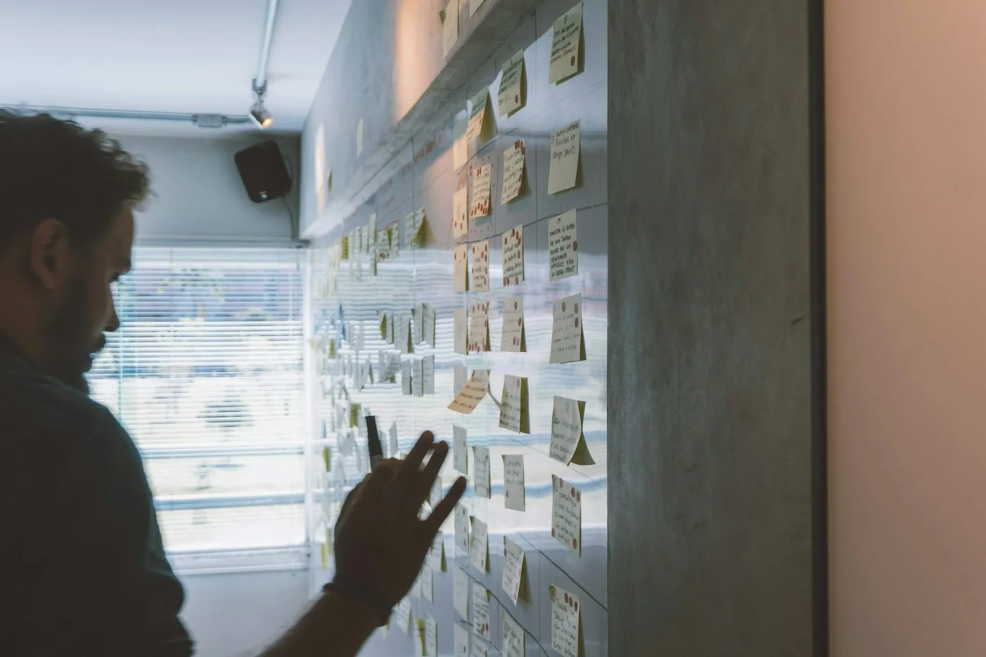 A designer arranging and reviewing notes during a planning session