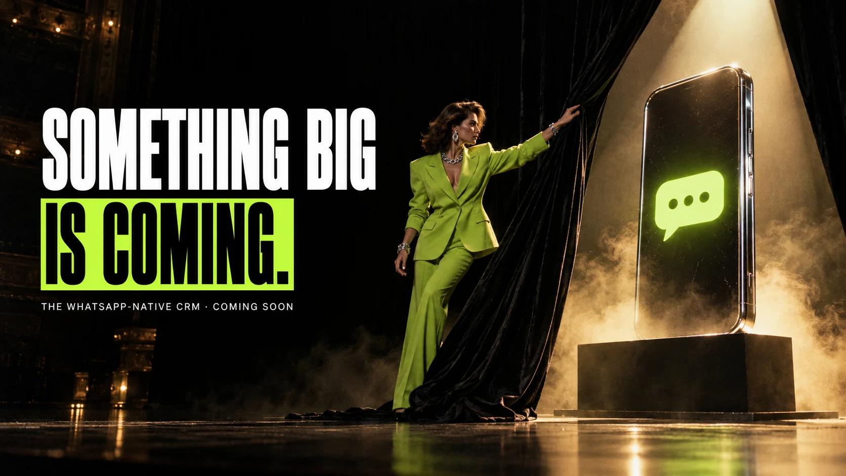 Campaign photograph: on a dark theatre stage, a woman in a lime suit pulls back a black velvet curtain to reveal a giant glowing phone with a lime chat bubble. Text: Something big is coming. The WhatsApp-native CRM · Coming soon.